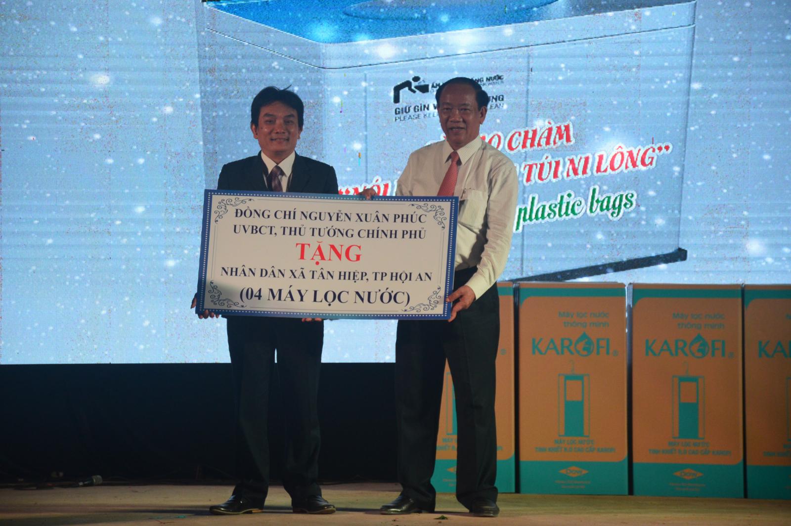 Chủ tịch UBND tỉnh Đinh Văn Thu thừa ủy quyền của Thủ tướng Chính phủ tặng 4 máy lọc nước cho nhân dân xã Tân Hiệp. Ảnh: Q.T